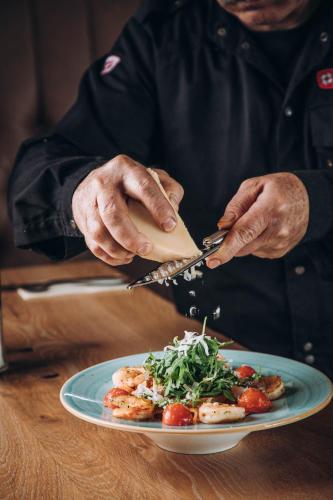 a man is preparing a plate of food at ANKERPUNKT Seeblick in Neutillmitsch