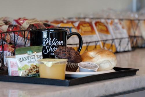 a tray with muffins and a cup of coffee and bread at Pelican Shores Inn in Lincoln City