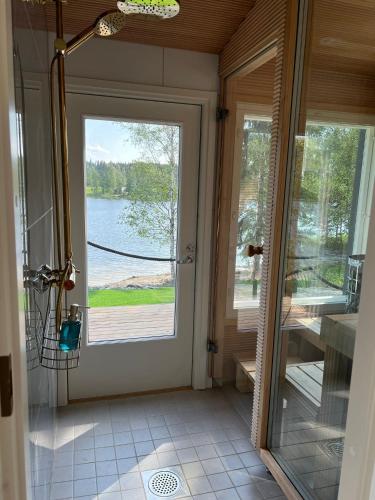 a door to a room with a view of a lake at Himosranta Suite with sauna in Jämsä