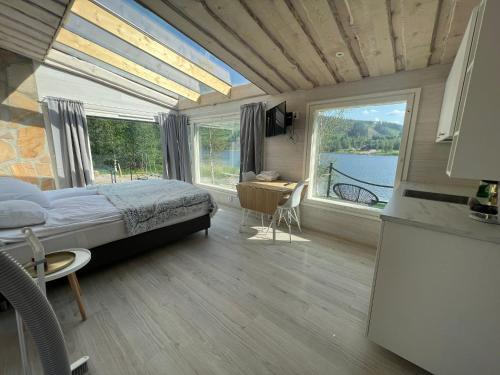 a bedroom with a bed and a desk and a kitchen at Himosranta Suite with sauna in Jämsä