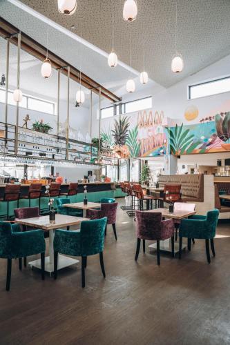 a restaurant with tables and chairs in a room at ANKERPUNKT Seeblick in Neutillmitsch