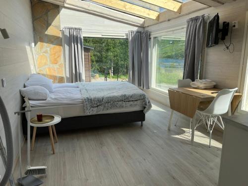 a bedroom with a bed and a desk and a window at Himosranta Suite with sauna in Jämsä
