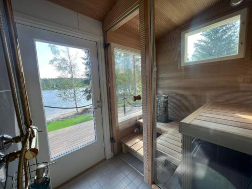 a screened in porch with a view of the water at Himosranta Suite with sauna in Jämsä