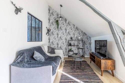 a living room with a couch and a piano at « L’atelier du 36 » Appartement à Montfort sur Meu in Montfort-sur-Meu