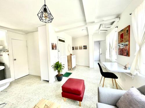 ein Wohnzimmer mit einem Sofa und einem roten Stuhl in der Unterkunft Spacious and comfortable apartment next to metro in Bello