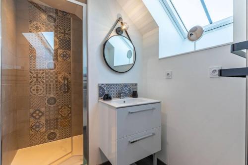 a bathroom with a sink and a mirror and a shower at « L’atelier du 36 » Appartement à Montfort sur Meu in Montfort-sur-Meu