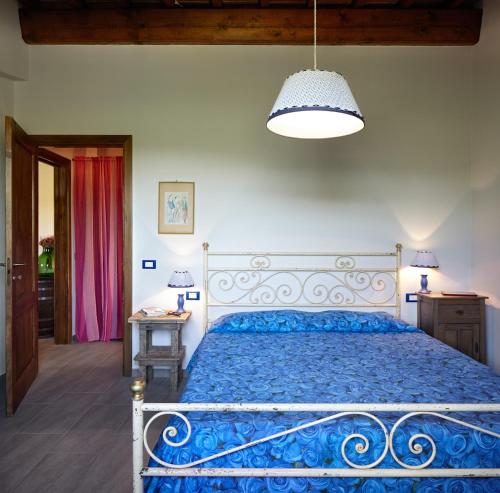 - une chambre avec un lit et une couette bleue dans l'établissement Podere La Casuccia, à Malmantile