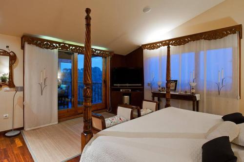Schlafzimmer mit einem großen Bett, einem Schreibtisch und Fenstern in der Unterkunft Fantástica casa con vistas al mar in Arenys de Munt