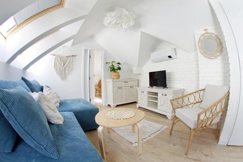 a living room with a blue couch and a table at Bryza in Łeba