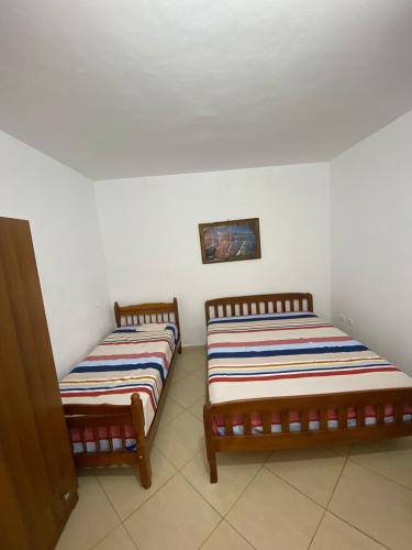 - deux lits assis l'un à côté de l'autre dans une pièce dans l'établissement Holiday Apartaments Durres, à Durrës