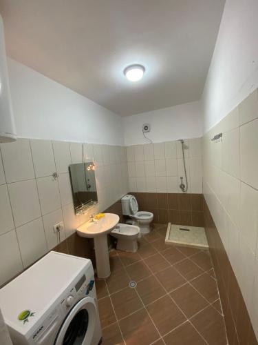 La salle de bains est pourvue d'un lavabo et de toilettes. dans l'établissement Holiday Apartaments Durres, à Durrës