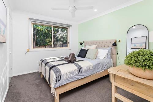 a bedroom with a bed and a window at La Casa Bella in Gerringong