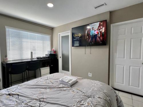 Modern 1 Bedroom Home W/ Sauna & Shower-Jets في كارسون: غرفة نوم مع سرير وتلفزيون بشاشة مسطحة على الحائط