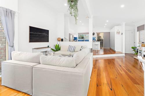 a white living room with a white couch at La Casa Bella in Gerringong