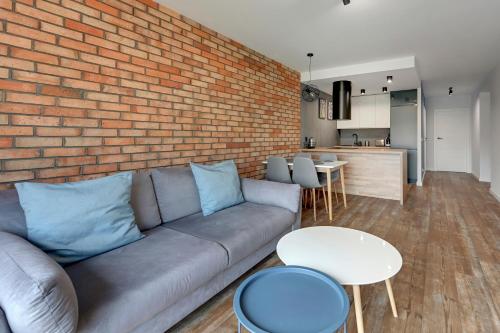 a living room with a couch and a brick wall at Rezydencja Wintera by Grand Apartments in Gdańsk