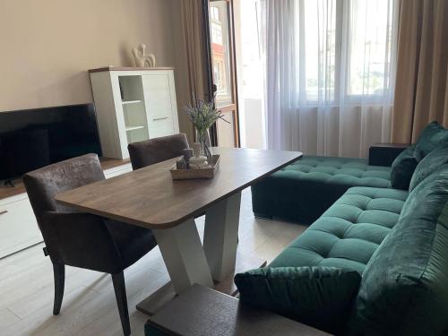 a living room with a table and a green couch at Catina`s Home in Burgas