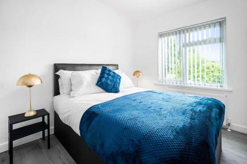 Un dormitorio con una cama con una manta azul. en 3 bed house/Free parking/contractors/Families en Bushbury
