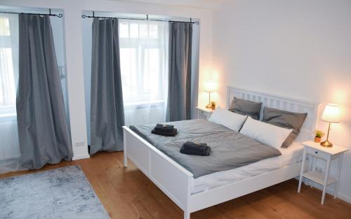 a bedroom with a white bed with two black bags on it at Modernes Studio Appartement mit Leseecke in Gernsbach