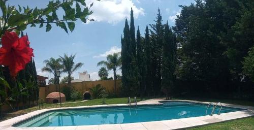 una piscina en un patio con árboles y una valla en Hotel Ollin Teotl, en San Juan Teotihuacán