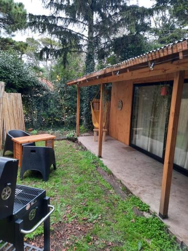 patio trasero con porche cubierto con mesa y sillas en PINAMARTE en Pinamar