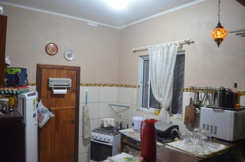 a small kitchen with a refrigerator and a counter top at Chácara piscina aquecida in Cotia