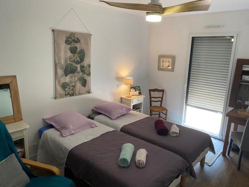 - une chambre avec deux lits, une chaise et une fenêtre dans l'établissement Cocon de douceur à deux pas de la gare, à Montauban-de-Bretagne