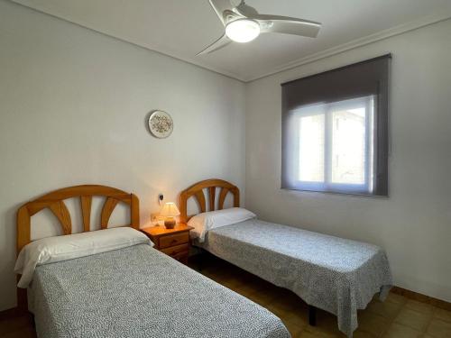 two beds in a room with a window at VACACIONES CHALET PEÑISCOLA 8-B Alquiler in Peñíscola