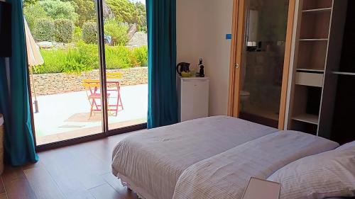 - une chambre avec un lit et une vue sur une terrasse dans l'établissement Agréable chambre dans le maquis, à Bonifacio