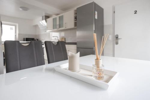 a white table with chopsticks and a vase on it at House by StayStay I 24 Hours Check-In in Nuremberg