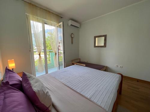 sypialnia z dużym łóżkiem i oknem w obiekcie Hocevar apartment w mieście Herceg Novi
