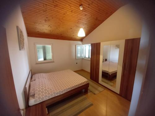 een kleine slaapkamer met een bed en een spiegel bij Apartman Privlaka in Privlaka