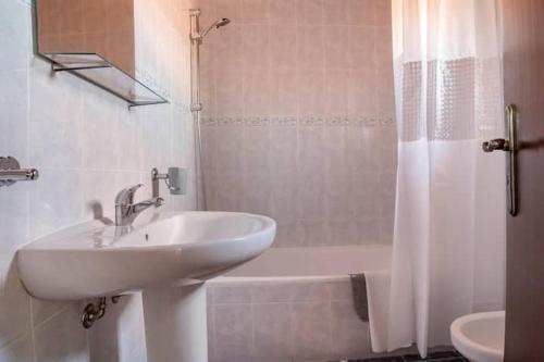 卡爾達斯達賴尼亞的住宿－Casa do Moleiro，浴室配有水槽、淋浴和浴缸。