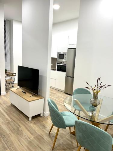 a living room with a table and chairs and a television at Loft RioArga. Comodidad y Estiloa a 5 min Centro. Nuevo!!! in Pamplona