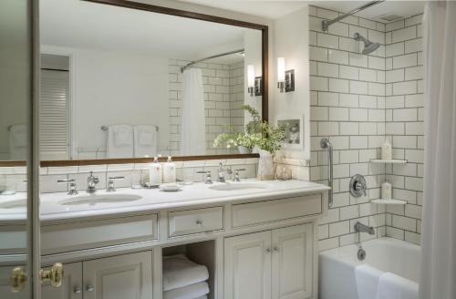 La salle de bains est pourvue de 2 lavabos et d'un grand miroir. dans l'établissement Woodstock Inn & Resort, à Woodstock