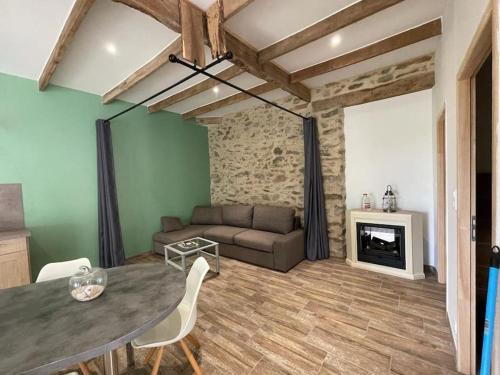 un salon avec un canapé et une table dans l'établissement Au grenier des chevaux - Gîte rénové - Baignoire Balnéo Lac privatif, à Trévien