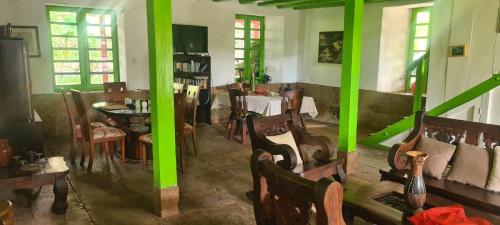 une pièce avec une table, des chaises et des piliers verts dans l'établissement Casa Altozano Hotel, à Fusagasuga