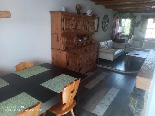 Haldi Apartment في Klosters Serneus: غرفة طعام مع طاولة وغرفة معيشة