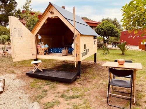 a wooden dog house with a table and a chair at Casa Provence Family & Friends Mare & Natura in Alghero