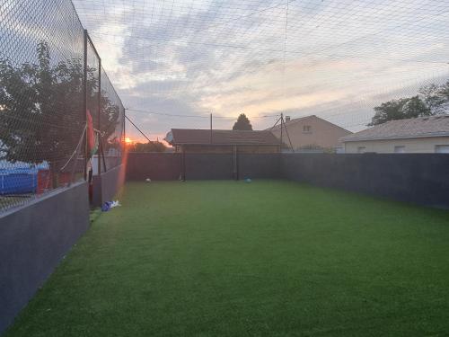 - un terrain de football avec une clôture et un ballon de football dans l'établissement Villa Caldas, à Sadirac