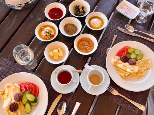 una mesa con platos de comida y tazas de café en Deadsea OCTAGON, en Madaba