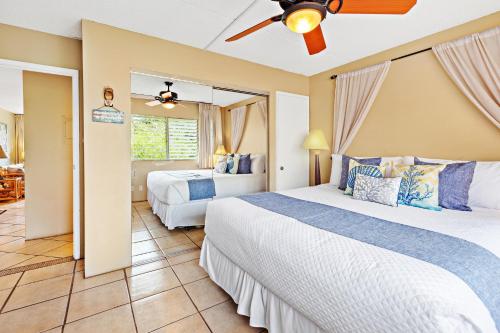 a bedroom with two beds and a ceiling fan at Kihei Kai Nani 368 in Kihei