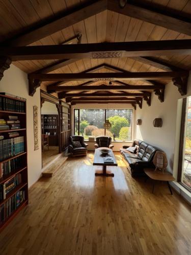 una sala de estar con techos de madera y una gran ventana. en House with a magical garden and sunroom en Höfn