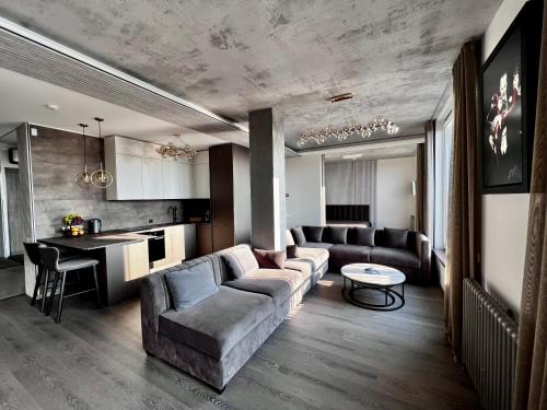 uma sala de estar com um sofá e uma mesa em Jonas Hill SkyView Apartment em Klaipėda