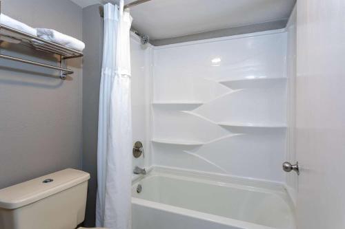 a white bathroom with a shower and a toilet at Baymont by Wyndham Marianna in Marianna