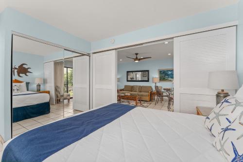 a bedroom with a bed and a living room at Hono Kai A4 in Wailuku