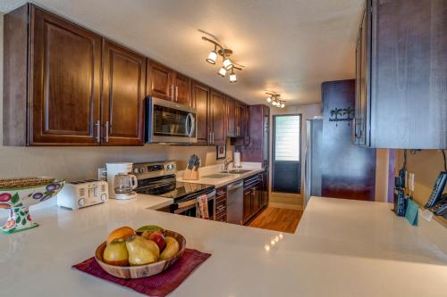 a kitchen with a bowl of fruit on a counter at Lauloa 102 in Wailuku