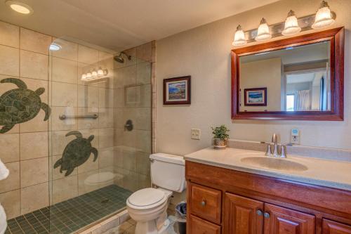 a bathroom with a shower and a toilet and a sink at Lauloa 102 in Wailuku