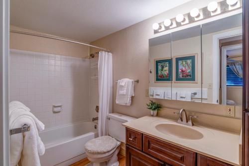 a bathroom with a sink and a tub and a toilet at Lauloa 102 in Wailuku