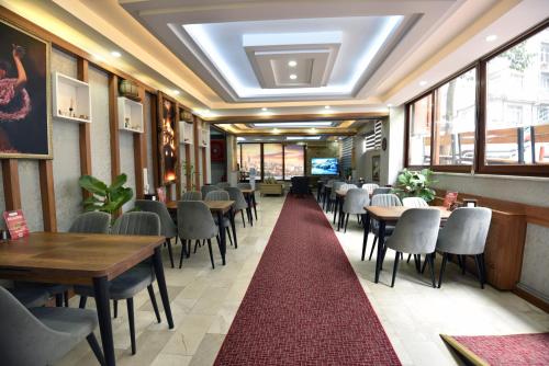 ein Restaurant mit Tischen und Stühlen und einem roten Teppich in der Unterkunft Cihangir by Aydin Suite Hotel in Istanbul