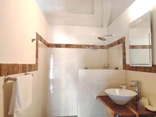a white bathroom with a sink and a mirror at HOTEL NIETO MOMPOX, ubicado en el corazón del centro histórico, frente al rio magdalena en zona de malecón in Mompos